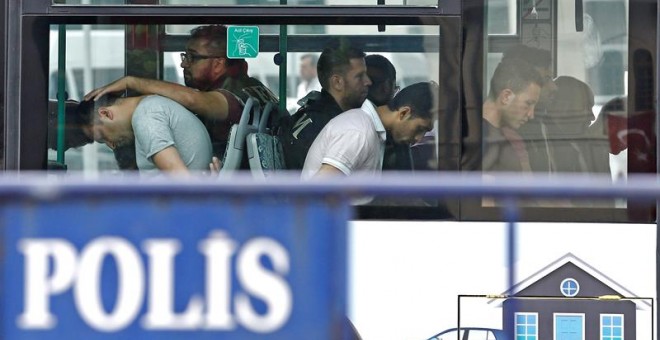 Policías turcos escoltan en un bus a soldados detenidos tras el golpe. - EFE