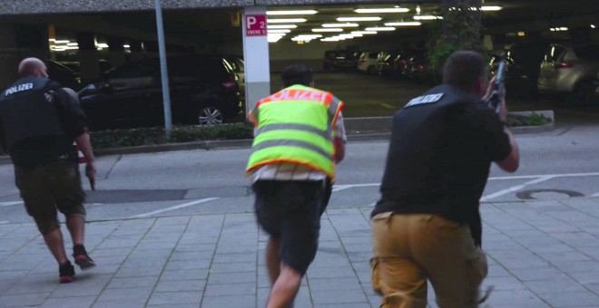 Una captura de pantalla de un vídeo muestra a policías con ropa de calle en el aparcamiento del centro comercial Olympia. REUTERS/Marc Mueller