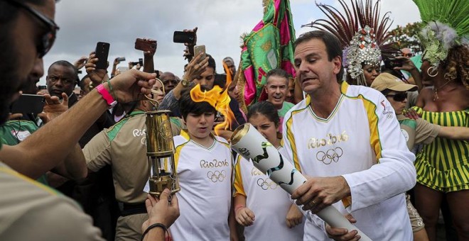 El alcalde de Río de Janeiro, Eduardo Paes (d), recibe la antorcha olímpica. /EFE