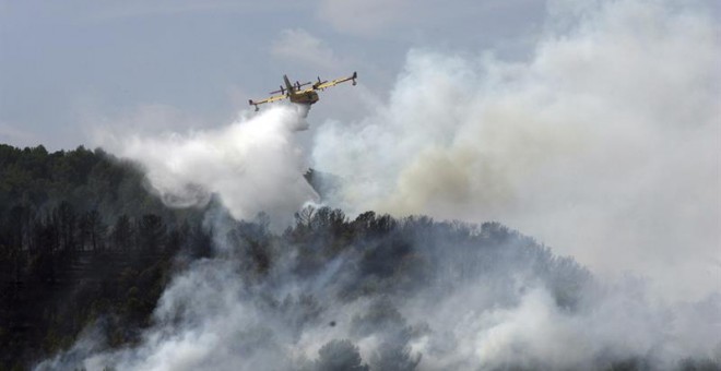 Imagen del incendio en La Pobla de Montornès (Tarragona) donde los Bomberos han desalojado hoy la parte alta de la urbanización Castell de Montornès como medida de precaución ante un incendio que arde sin control en una zona forestal de difícil acceso. EF