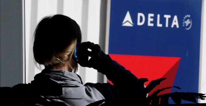 Un viajero habla por su móvl junto a un puesto de la aerolínea Delta Airlines en el aeropuerto de Salt Lake City (Utah, EEUU). REUTERS/George Frey