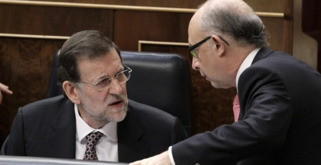 El presidente del Gobierno en funciones, Mariano Rajoy, conversa con el ministro de Hacienda y Administraciones públicas en funciones, Cristóbal Montoro, en una foto de archivo.- EFE