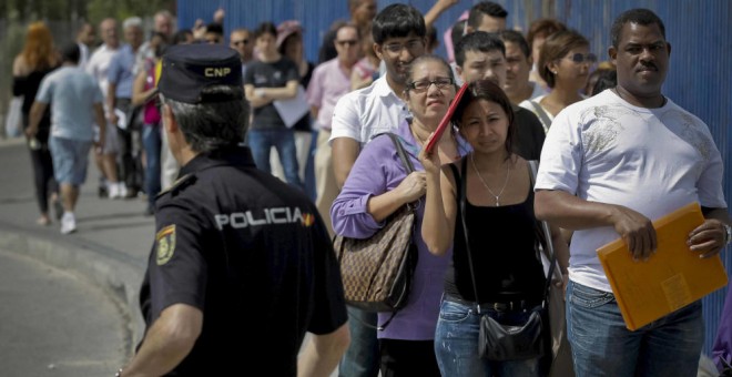 nmigrantes hacen cola a la entrada de la Brigada Provincial de Extranjería y Fronteras. EFE