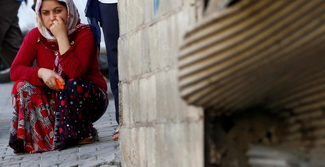 Una mujer acuclillada cerca del local donde se celebraba una boda objeto de un ataque terrorista suicida en la localidad turca de Gaziantep. REUTERS/Osman Orsal