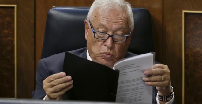 El ministro de Asuntos Exteriores, José Manuel García-Margallo siguen desde su escaño la intervención del presidente del Gobierno en funciones, Mariano Rajoy, durante la primera jornada del debate de investidura a la que se somete, esta tarde en el Congre