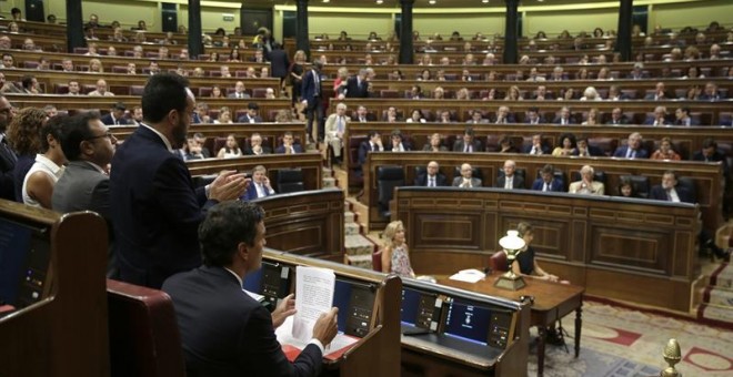 La bancada socialista aplaude a su líder, Pedro Sánchez (i), tras su intervención esta mañana en el Congreso de los Diputados, con la que se ha reanudado hoy la segunda sesión del debate de investidura del líder del PP, Mariano Rajoy (abajo - d).- EFE/Em