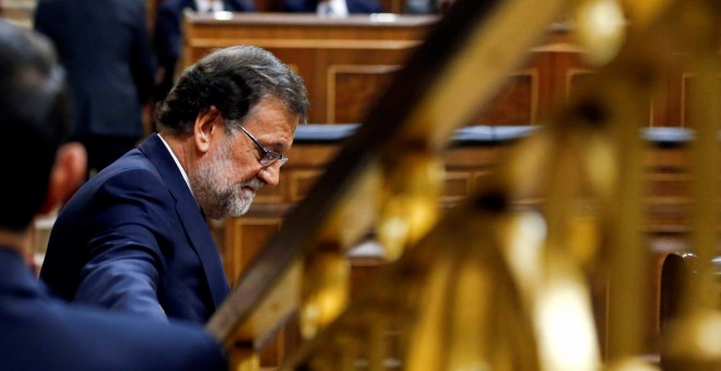 El candidato del PP a la investidura y presidente del Gobierno en funciones, Mariano Rajoy, junto a su escaño en el Congreso de los Diputados, en la segunda sesión del debate de investidura. REUTERS/Andrea Comas