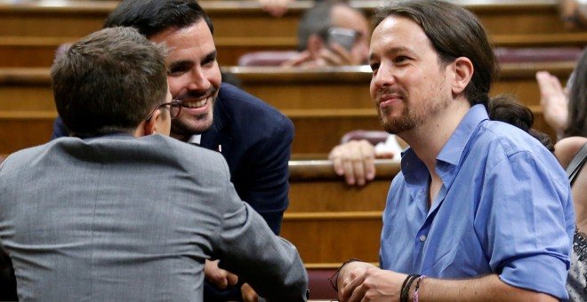 El líder de Podemos, Pablo Iglesias, conversa con el coordinador general de IU, Alberto Garzón, y elnúmero dos de la formación morada, Inigo Errejon, en el Congreso, durante la fallida investidura de Mariano Rajoy. REUTERS/Andrea Comas