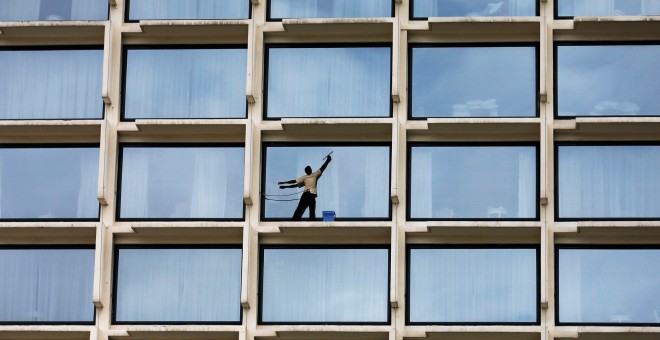 Un trabajador limpia los cristales de un hotel de lujo en Colombo, Sri Lanka. REUTERS/Dinuka Liyanawatte