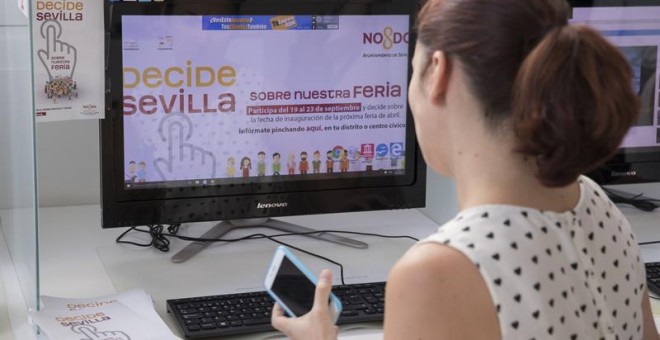 Una chica votando en la plataforma de 'Decide Sevilla' la duración de la Feria de Abril/EFE