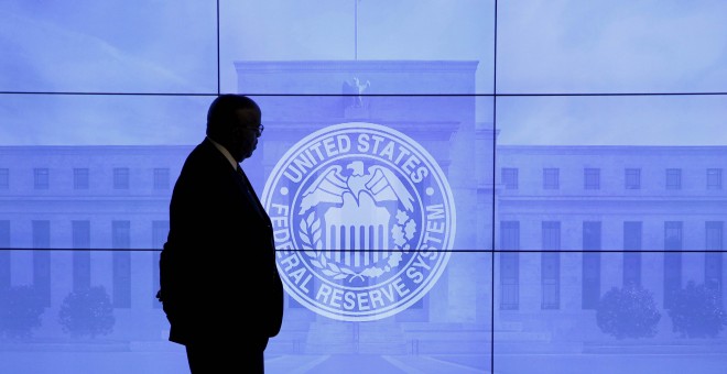 Un guardia de seguridad pasa por delnate de una imagen de la Reserva Federal en la sede del banco central estadounidense, en Washington. REUTERS/Kevin Lamarque