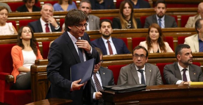 El presidente catalán, Carles Puigdemont, se dirige a la tribuna para su intervención en el debate de la cuestión de confianza, la primera que vive el Parlament desde que fue restablecido y para la que ya cuenta con el aval de la CUP, en la que el preside