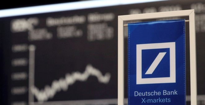 El logo de Deutsche Bank frente al panel informativo de la bolsa de Fráncfort que muestra la evolución de su principal indicador, el DAX. REUTERS/Kai Pfaffenbach