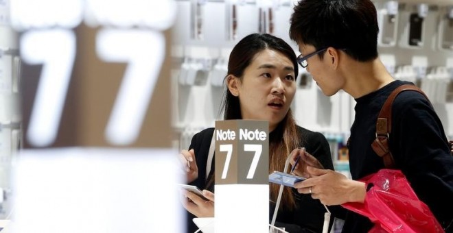 Una pareja examina un Galaxy Note 7 en la sede de Samsung  en Seúl. REUTERS/Kim Hong-Ji