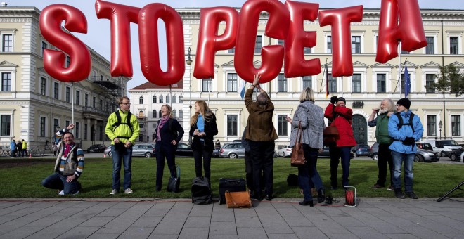 Unas personas se manifiestan en contra el acuerdo de libre comercio entre la UE y Canadá (CETA, por sus siglas en inglés) frente al Ministerio del Interior del estado federado alemán de Baviera en Múnich. EFE