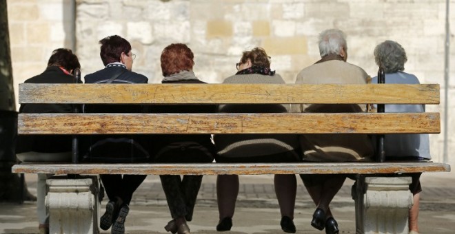 Varios pensionistas sentados en un banco en la localidad burgalesa de Briviesca. AFP