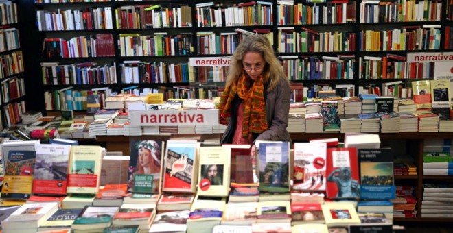 Imagen de archivo de una mujer hojeando unos libros en una librería de Barcelona. EFE