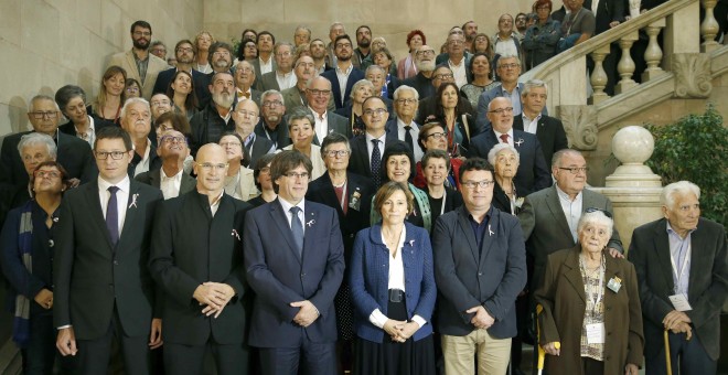 El presidente de la Generalitat Carles Puigdemont y la presidenta del Parlament de Cataluña Carme Forcadell junto a otros diputados, posan con familiares y víctimas del franquismo tras la sesión que ha acordado por unanimidad tramitar la proposición de le