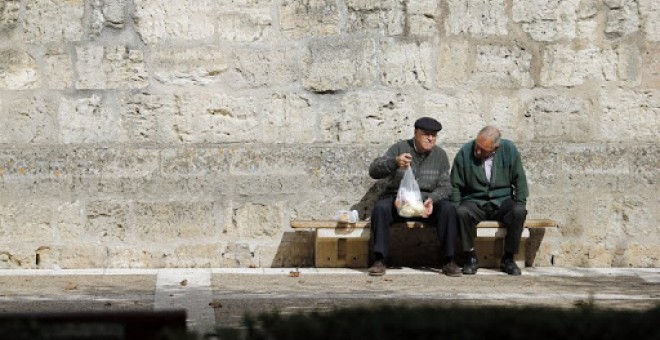 Ancianos en un banco en la localidad burgalesa de Briviescas. / AFP