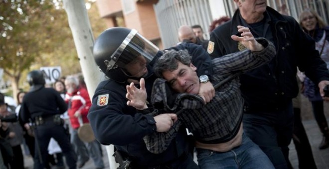 Un agente detiene a un ciudadano que participaba en una manifestación. / EFE