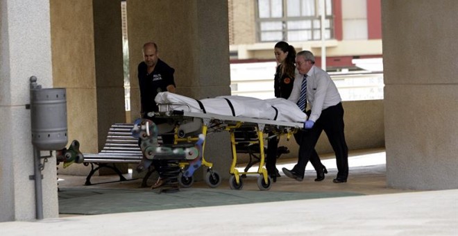 Miembros del retén fúnebre retiran el cuerpo de la mujer de nacionalidad belga asesinada. /EFE