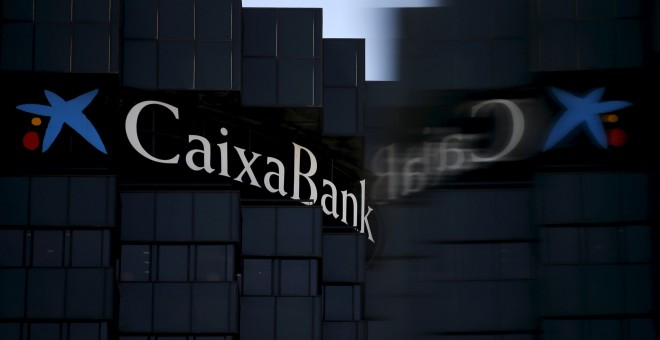 El logo de CaixaBank se refleja en un cristal, en la sede de la entidad en Barcelona. REUTERS/Albert Gea