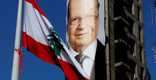 Bandera Libanesa frente al cartel de Michel Aoun. / REUTERS
