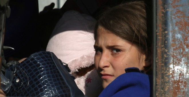 Una niña huye del conflicto en Siria. / REUTERS