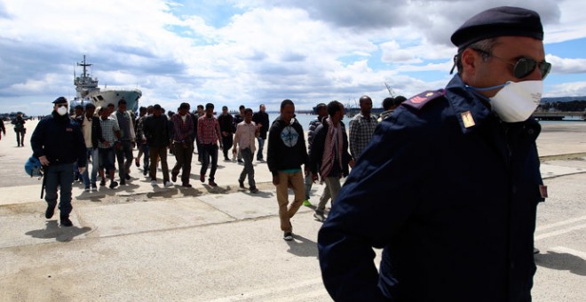 Imagen de archivo de la Policía italiana escoltando a un grupo de inmigrantes en el puerto siciliano de Augusta. REUTERS