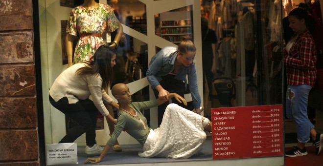 Dos empleadas de una tienda en el centro de Madrid arreglan en el escaparate. REUTERS