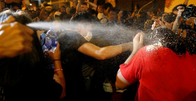 Un policía rocía con gas pimienta a un manifestante.- REUTERS/Tyrone Siu