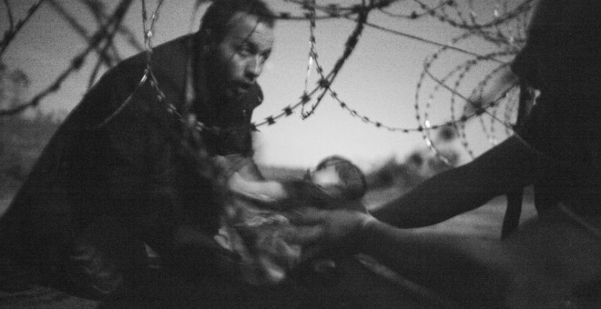 Un bebé es entregado a través de una alambrada de púas a un refugiado sirio que ha conseguido cruzar la frontera de Serbia a Hungría, cerca de Röszke, el 28 de agosto. - WARREN RICHARDSON / Primer premio Fotografías Individuales WPF 2015