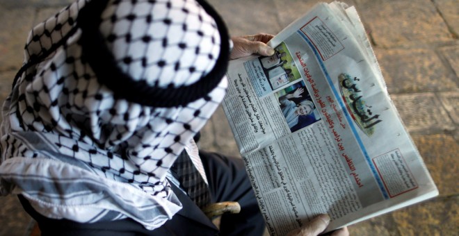 Un palestino lee en el diario 'Al-Quds' la noticia de las elecciones en EEUU. REUTERS/Ammar Awad