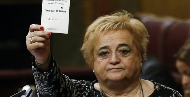 Ana Surra, diputada de ERC, muestra su tarjeta de refugiada de los años 70, cuando huyó de la dictadura de su país de origen, Uruguay. REUTERS / ANDREA COMAS