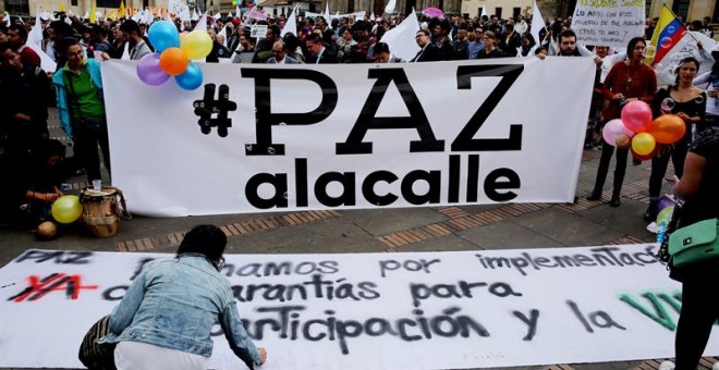 Cientos de personas se congregan en la Plaza de Bolívar para observar la firma del nuevo acuerdo de paz, que termina 52 años de conflicto armado interno, este jueves en Bogotá (Colombia). / EFE