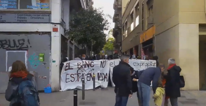 Un momento de la manifestación en la que los presentes portan pancantartas con los mensajes 'el banco no está en venta' y 'el Banc expropiat se queda en Gràcia'. / TWITTER