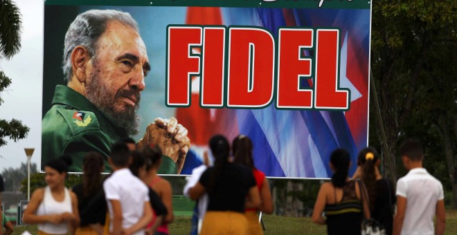 La gente espera frente a una valla publicitaria de Fidel Castro con el mensaje 'hasta la victoria, siempre' en Santa Clara. REUTERS