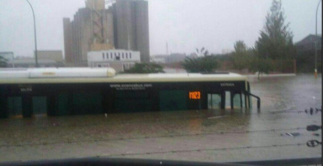 Un autobús rodeado de agua en Málaga, en una foto publicada en Twitter.-