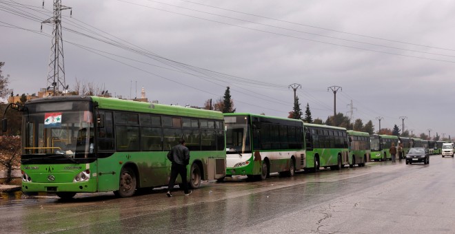 Los autobuses que iban a evacuar a los ciudadanos de Alepo, esperando en fila esta mañana. / REUTERS