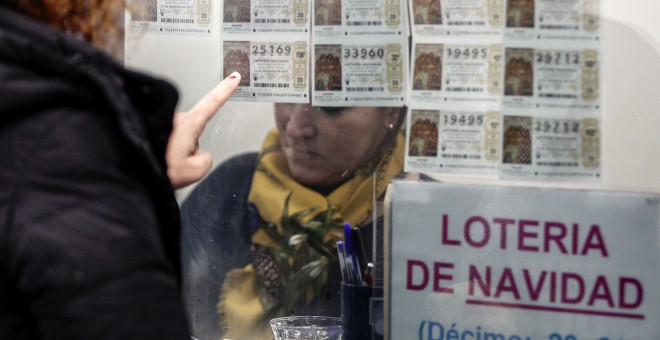 Una mujer escoge un décimo en una administración de Lotería en Valencia. EFE/Manuel Bruque