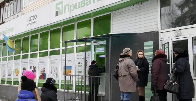 Varias personas hacen colca ante un cajero automático del banco PrivatBank, en una sucursal en Kiev. REUTERS/Valentyn Ogirenko