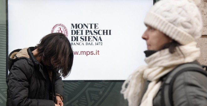 Varios peatones pasan junto a una oficina de Monte Dei Paschi di Siena (BMPS) en Roma. AFP/ Tiziana Fabi