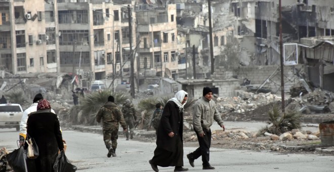 Varias personas caminan por los distritos de Zabadia y Salah Eddin en Alepo el 23 de diciembre. EFE