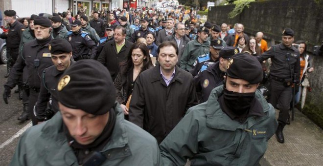 Concejales de Ponteareas salen escoltados del pleno por la policía tras una protesta de los preferentistas. / EFE