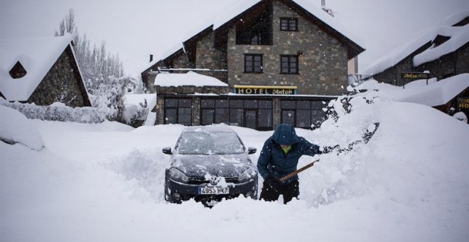 Un hombre intenta desenterrar su coche en Benasque, tras la gran nevada caída en el Pirineo ayer. /EFE