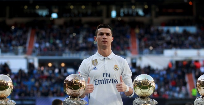 Cristiano Ronaldo posa con sus cuatros Balones de Oro en el Bernabéu. /REUTERS