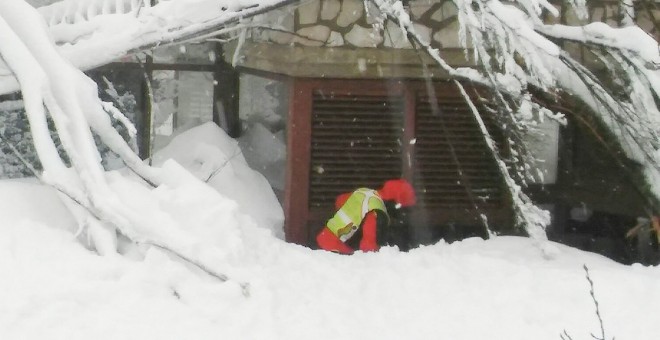 Un miembro del equipo de rescate alpino y espeleológico del Lacio se ve delante del Hotel Rigopiano en Farindola/ REUTERS