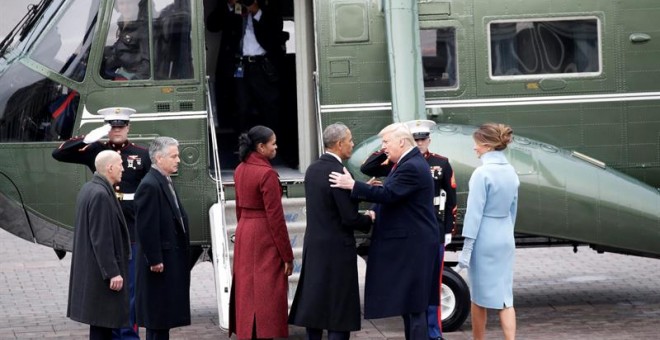 Barack y Michelle Obama son acompañados por Trump a un helicóptero militar para su salida del Capitolio tras la ceremonia de investidura. -  EFE/John Angelillo