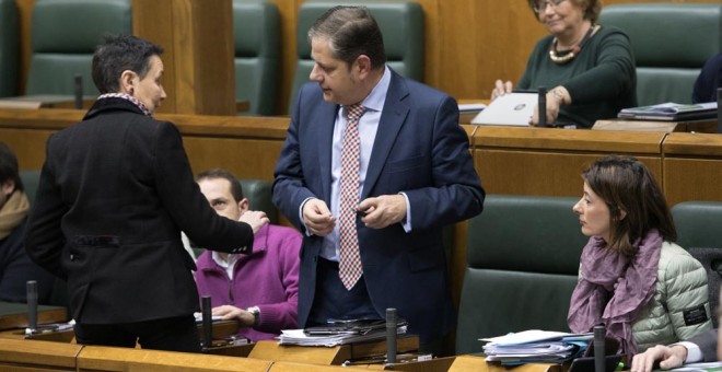 La parlamentaria de EH Bildu Jone Goirizelaia (i) conversa con el parlamenatrio del PP Javier Arbulo, en el Pleno del Parlamento Vasco. EFE/ADRIÁN RUIZ DE HIERRO