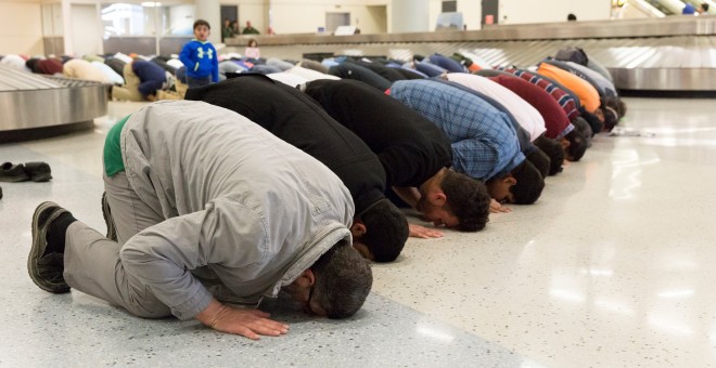 Varias personas rezan como los musulmanes en el aeropuerto internacional de Dallas como parte de las protestas que se están produciendo en todo EEUU contra el veto de Trump a los inmigrantes.  REUTERS / Laura Buckman